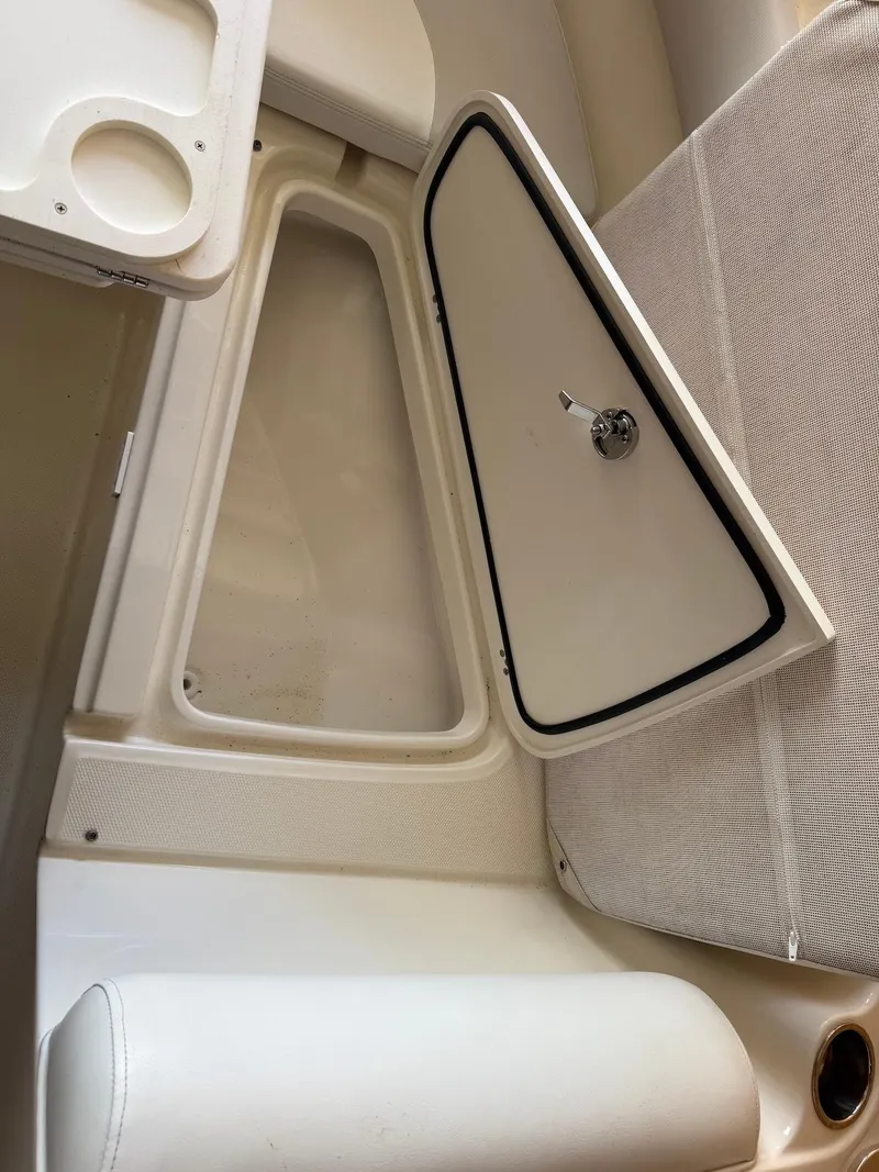 Slide: The Image of 2012 Edgewater 245 CX boat interior with open storage compartment and seating. - 12
