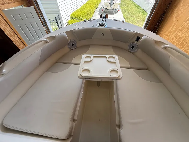 Slide: The Image of 2012 Edgewater 245 CX boat interior with cushioned seating and a central table. - 15