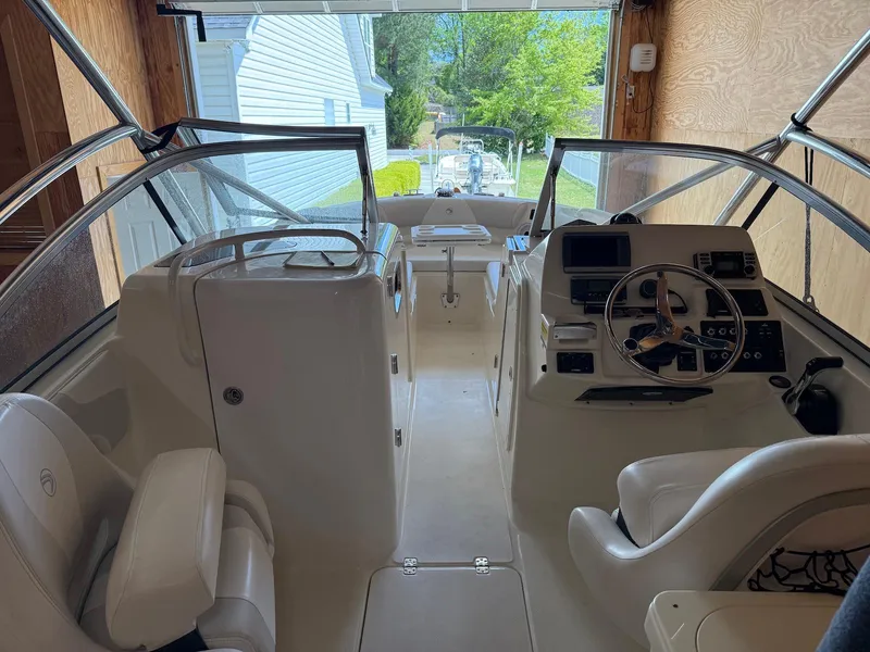 Slide: The Image of Interior view of 2012 Edgewater 245 CX boat, featuring steering console and seating. - 2