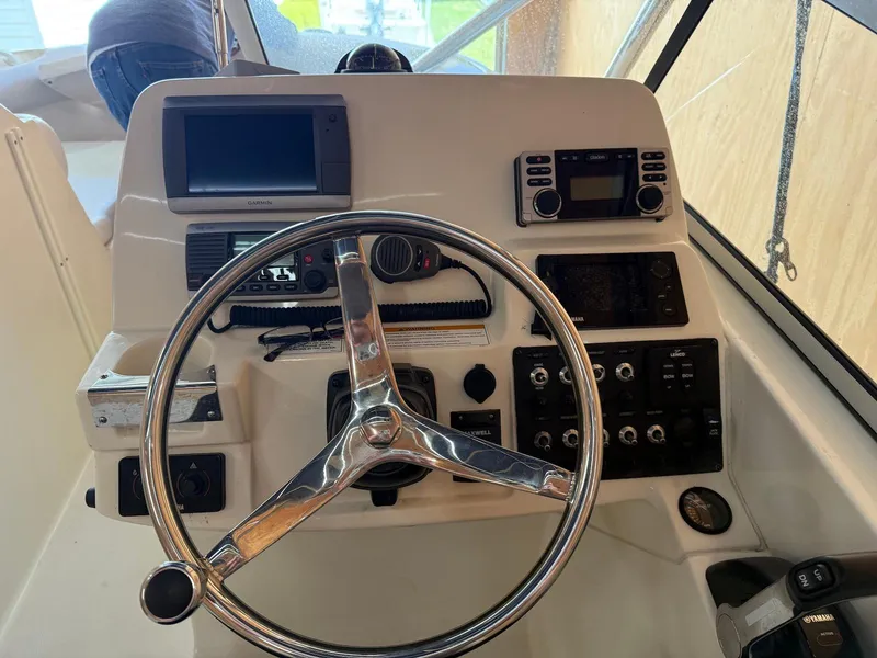 Slide: The Image of Control panel of a 2012 Edgewater 245 CX boat with steering wheel and navigation instruments. - 21