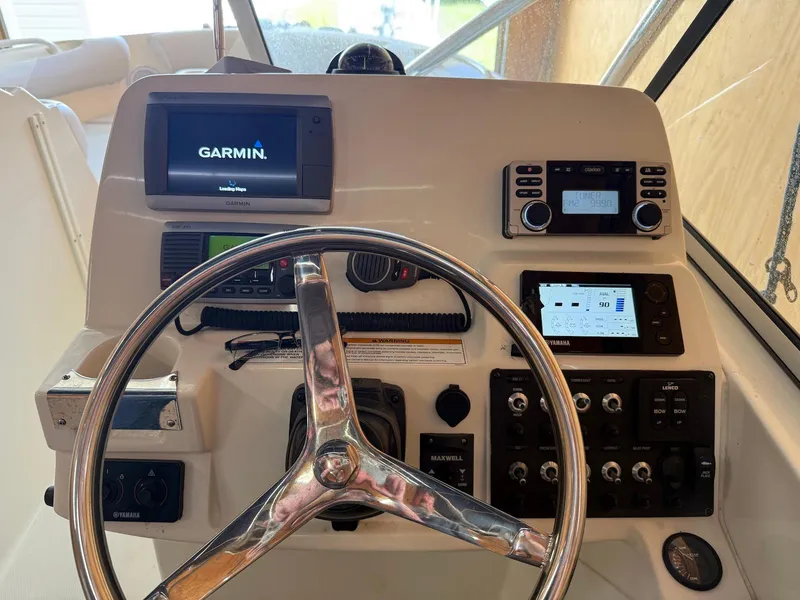 Slide: The Image of Helm of 2012 Edgewater 245 CX boat with Garmin navigation system and controls. - 24