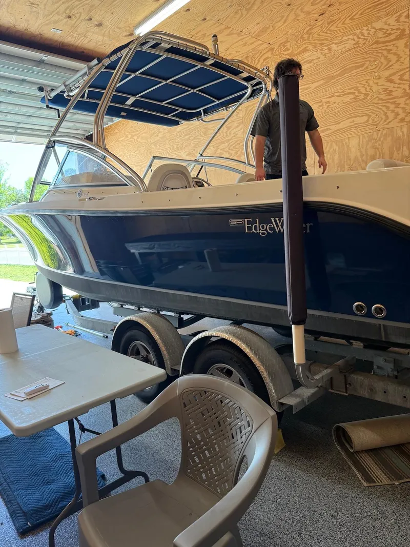 Slide: The Image of 2012 Edgewater 245 CX boat on trailer in garage setting. - 34