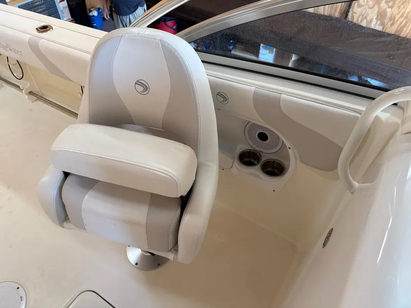 Slide: The Image of Captain's chair on 2012 Edgewater 245 CX boat, featuring cup holders and speaker. - 4