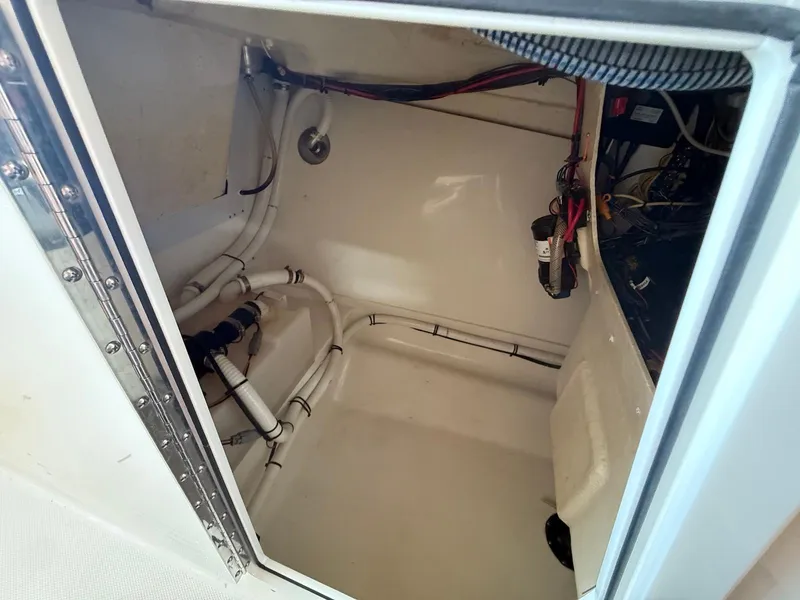 Slide: The Image of 2012 Edgewater 245 CX boat compartment with visible wiring and plumbing. - 8