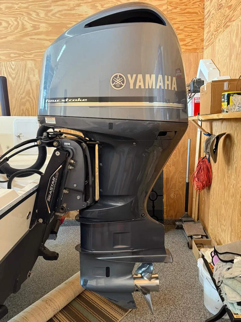 Slide: The Image of 2012 Edgewater 245 CX with Yamaha outboard motor in a garage setting. - 9