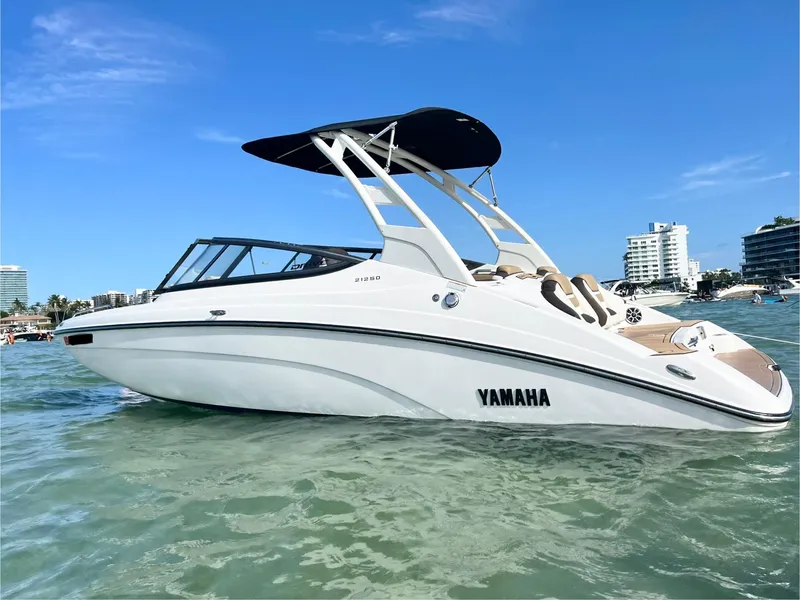 Slide: The Image of 2022 Yamaha Boats 212SD on water, sleek design, sunny day, cityscape background. - 5