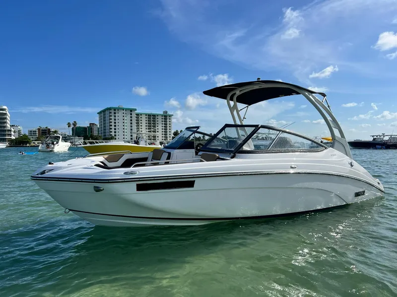 Slide: The Image of 2022 Yamaha Boats 212SD in clear water, with modern buildings in the background. - 6