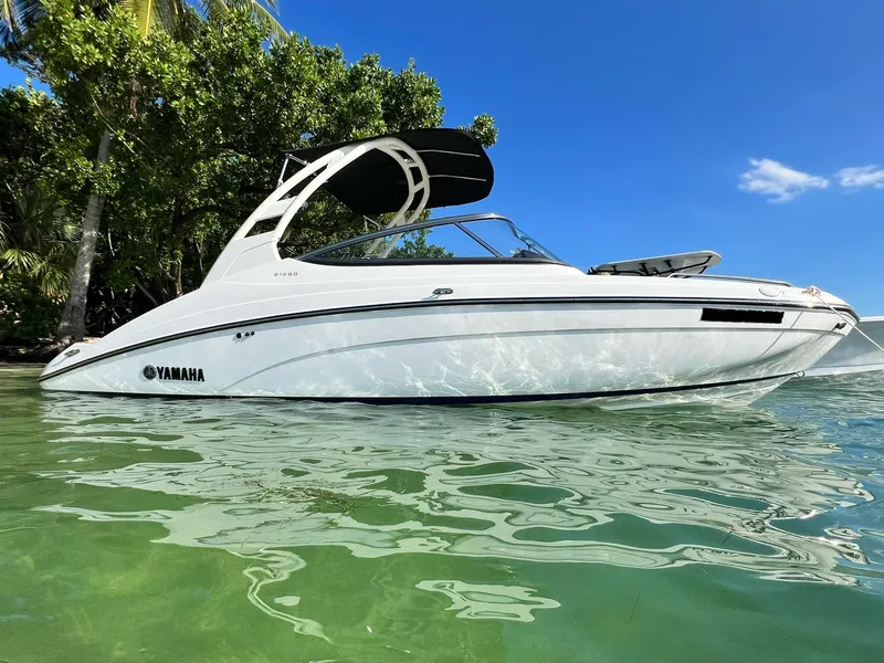 Slide: The Image of 2022 Yamaha Boats 212SD in clear water, with lush greenery and blue sky background. - 7