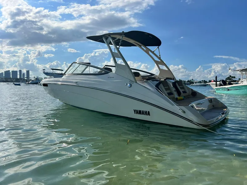 Slide: The Image of 2022 Yamaha Boats 212SD in calm waters under a clear blue sky. - 9
