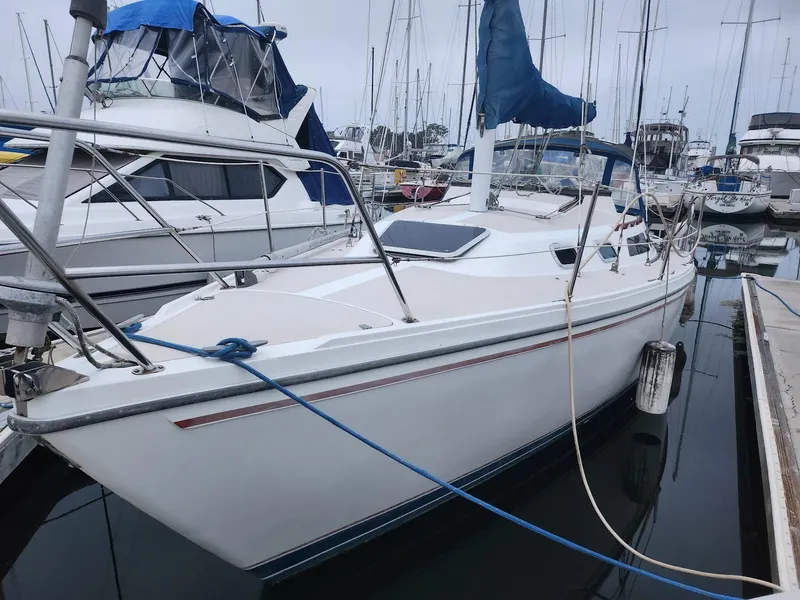 The Image of 1987 Catalina 30 Mk II sailboat docked in marina, featuring sleek white hull and blue sail cover. - 1