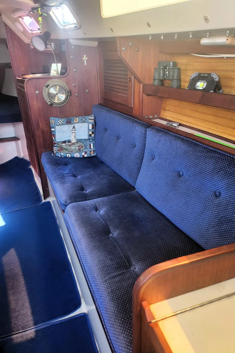Slide: The Image of Interior of a 1987 Catalina 30 Mk II sailboat with blue cushioned seating. - 13