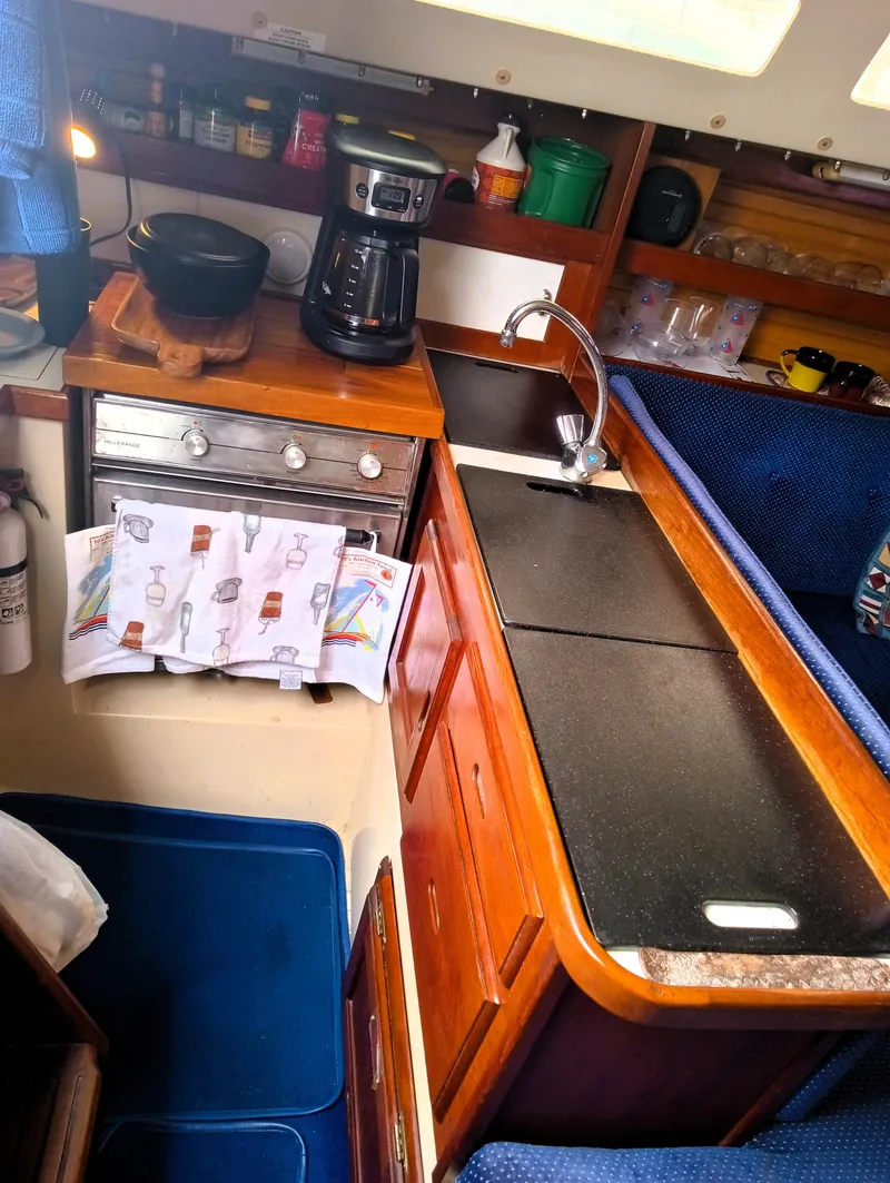 Slide: The Image of Compact kitchen in a 1987 Catalina 30 Mk II sailboat with stove, sink, and storage. - 18