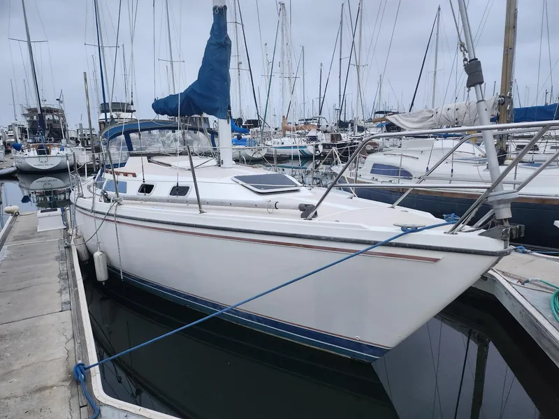 Slide: The Image of 1987 Catalina 30 Mk II sailboat docked in a marina, featuring a blue sail cover. - 2
