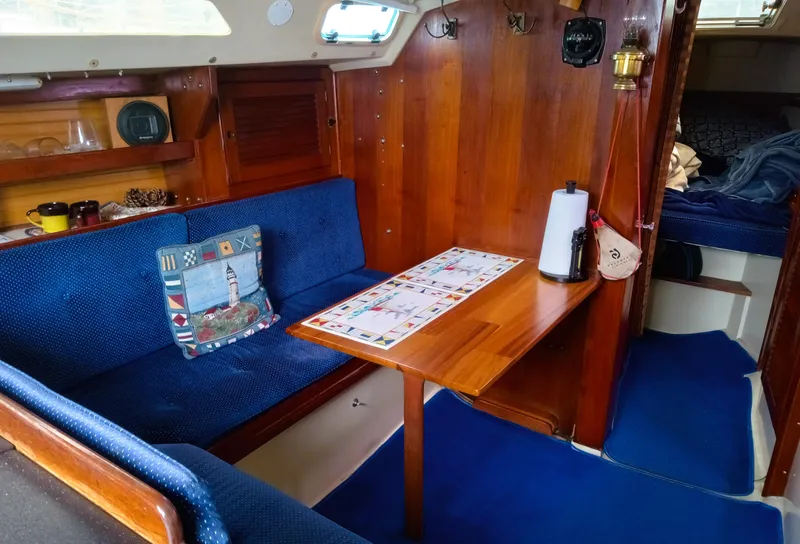 Slide: The Image of Interior of 1987 Catalina 30 Mk II sailboat with blue seating and wooden table. - 22