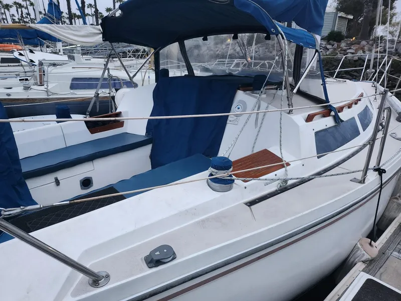 Slide: The Image of 1987 Catalina 30 Mk II sailboat docked, featuring blue canvas covers and spacious cockpit. - 3