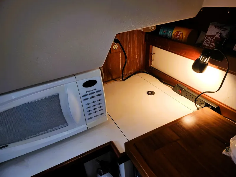 Slide: The Image of Compact kitchen area in a 1987 Catalina 30 Mk II sailboat with microwave and lighting. - 4