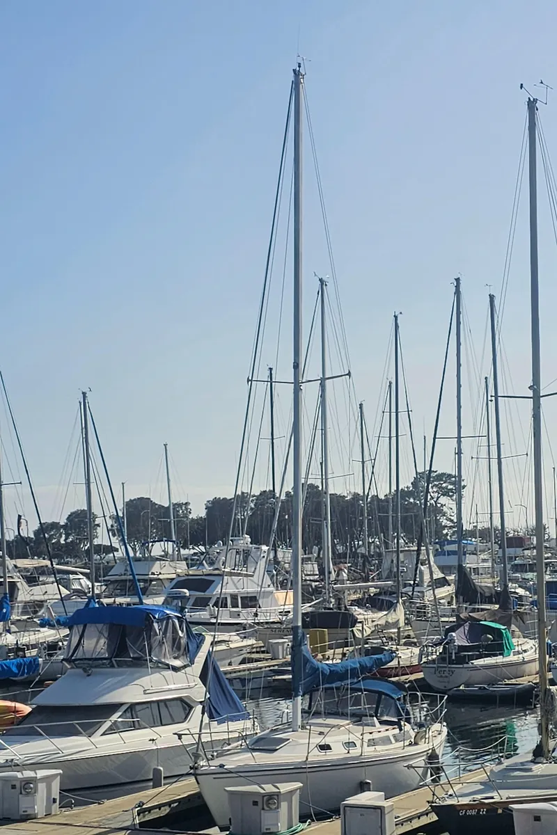 Slide: The Image of Marina with various sailboats, including a 1987 Catalina 30 Mk II, under a clear blue sky. - 7