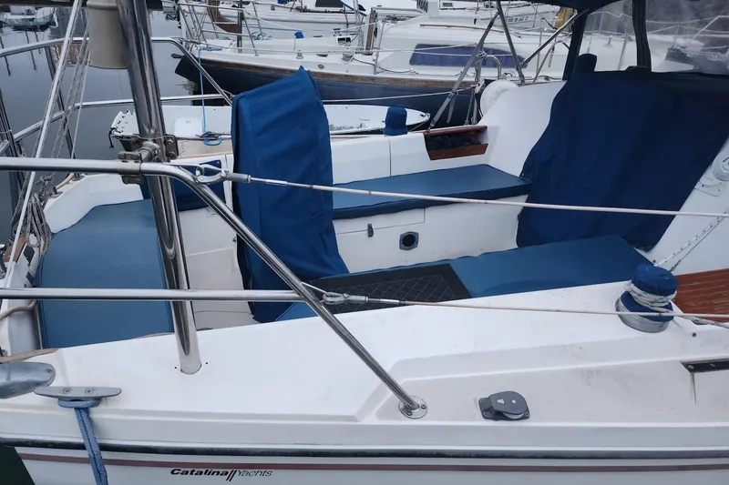 Slide: The Image of 1987 Catalina 30 Mk II sailboat with blue seating, docked in a marina. - 8