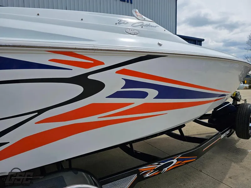 Slide: The Image of 2005 Baja 25 Outlaw boat with vibrant orange and blue graphics on a trailer. - 11