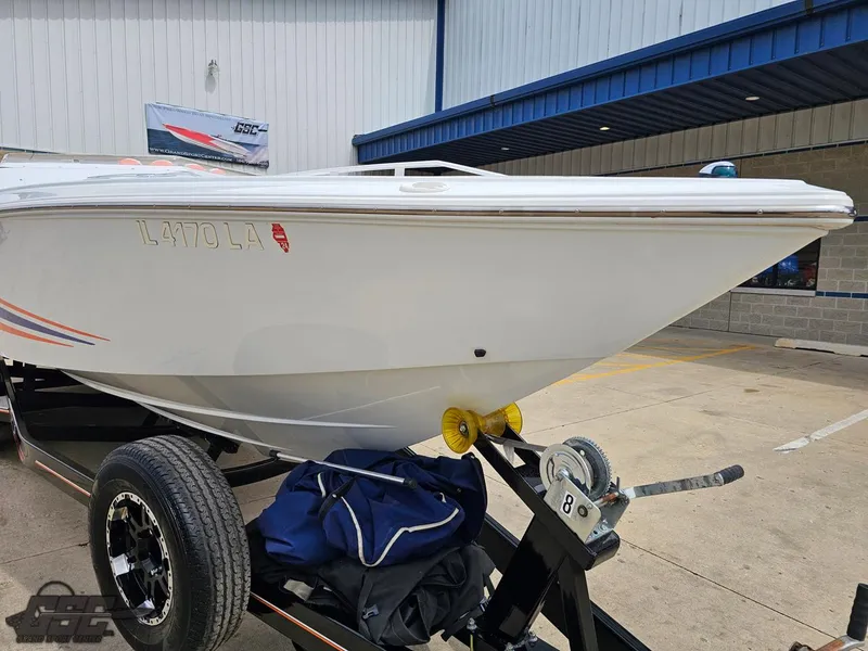 Slide: The Image of 2005 Baja 25 Outlaw boat on trailer, parked outside a building. - 14