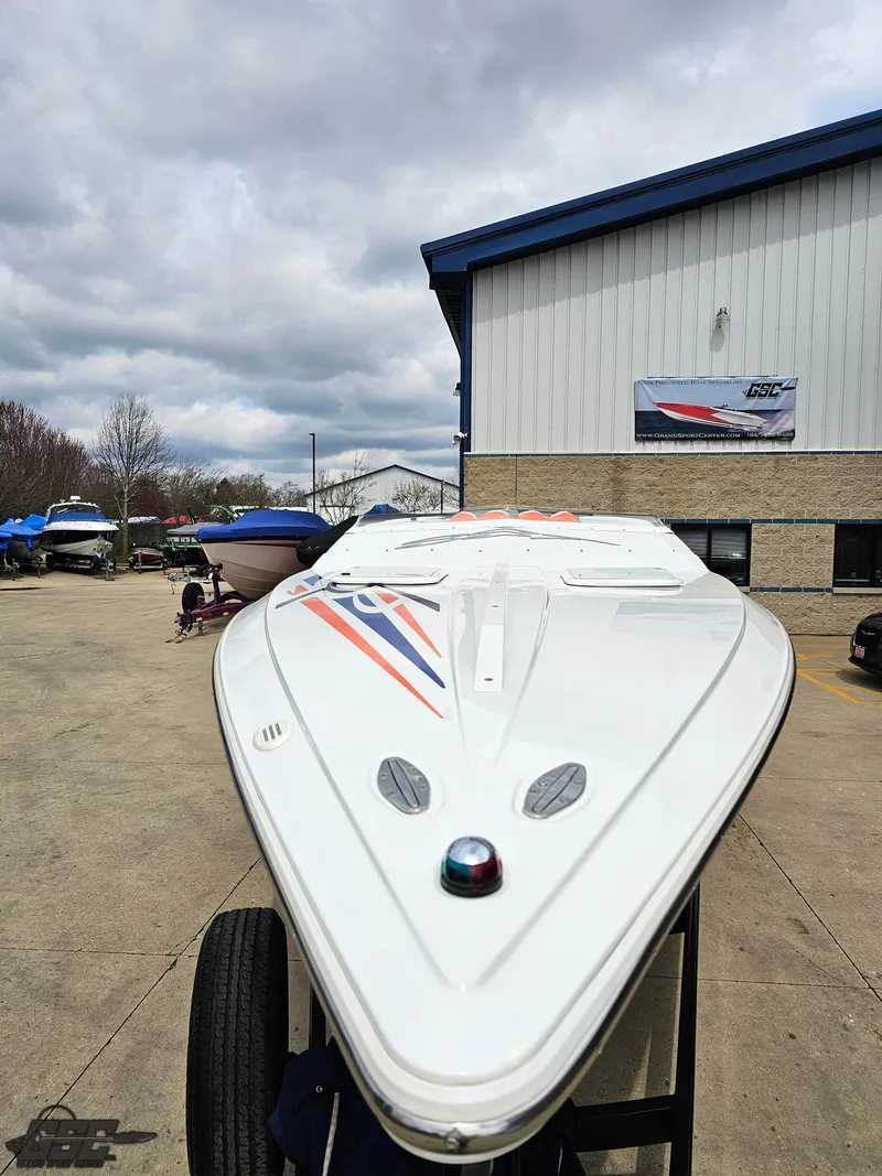 Slide: The Image of 2005 Baja 25 Outlaw boat with sleek design, parked outdoors near a building. - 16