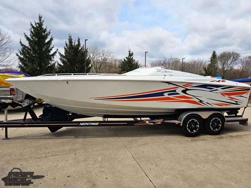 Slide: The Image of 2005 Baja 25 Outlaw speedboat with vibrant graphics on a trailer, parked outdoors. - 19