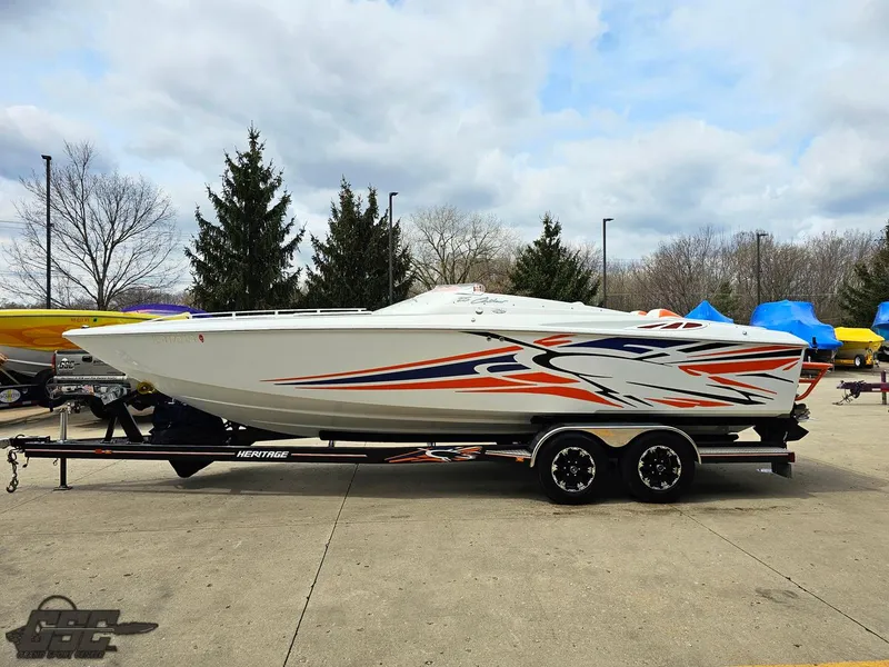 Slide: The Image of 2005 Baja 25 Outlaw speedboat with vibrant graphics on a trailer, parked outdoors. - 20
