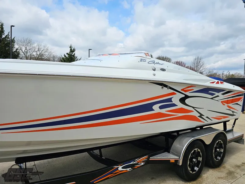 Slide: The Image of 2005 Baja 25 Outlaw speedboat with vibrant orange and blue graphics on a trailer. - 23