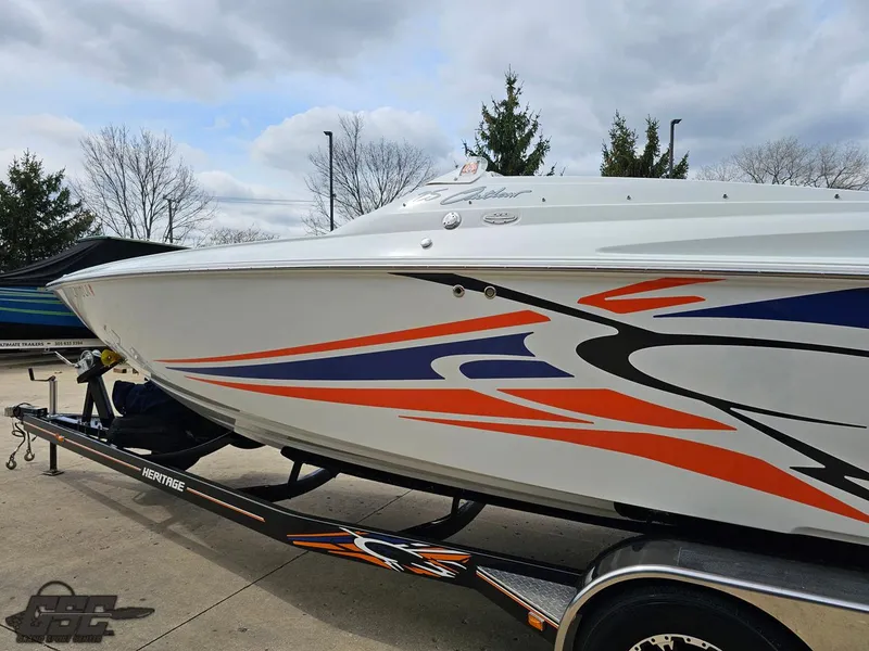 Slide: The Image of 2005 Baja 25 Outlaw boat with vibrant graphics on a trailer, parked outdoors. - 27