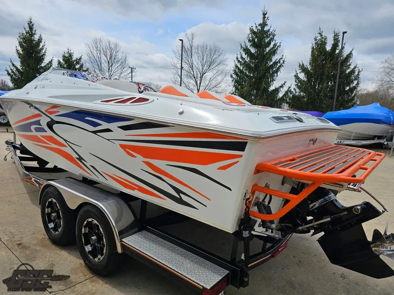 Slide: The Image of 2005 Baja 25 Outlaw boat with vibrant orange and black graphics on a trailer. - 30