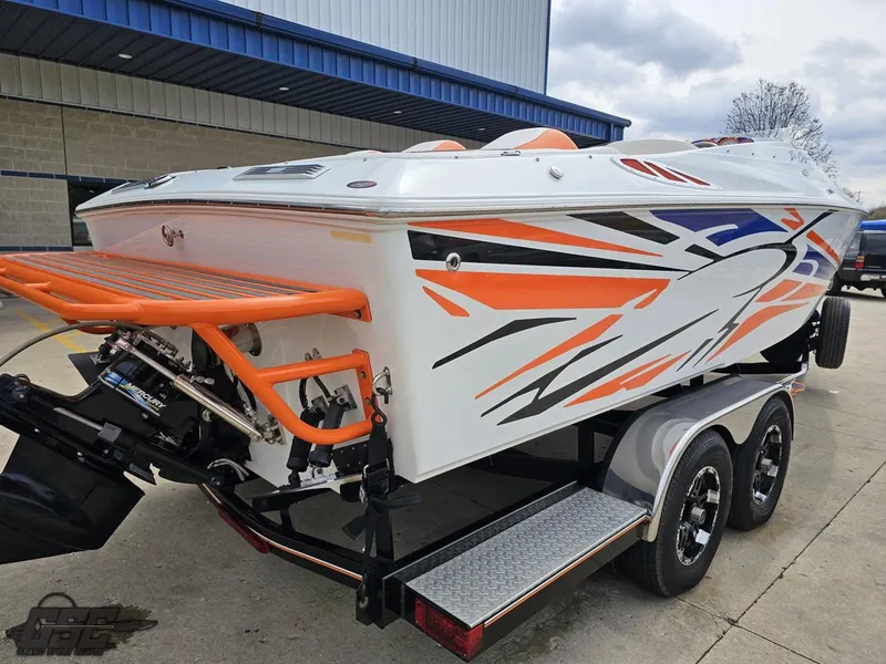 Slide: The Image of 2005 Baja 25 Outlaw boat with vibrant orange and black graphics on a trailer. - 38