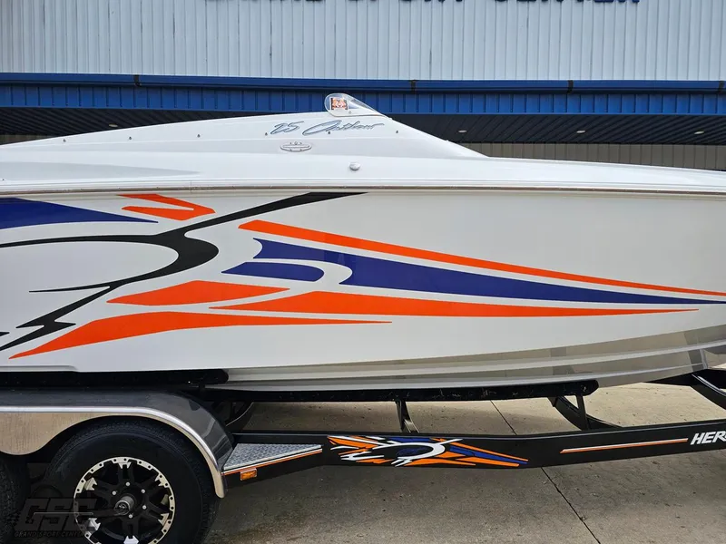 Slide: The Image of 2005 Baja 25 Outlaw boat with vibrant orange and blue graphics on a trailer. - 6