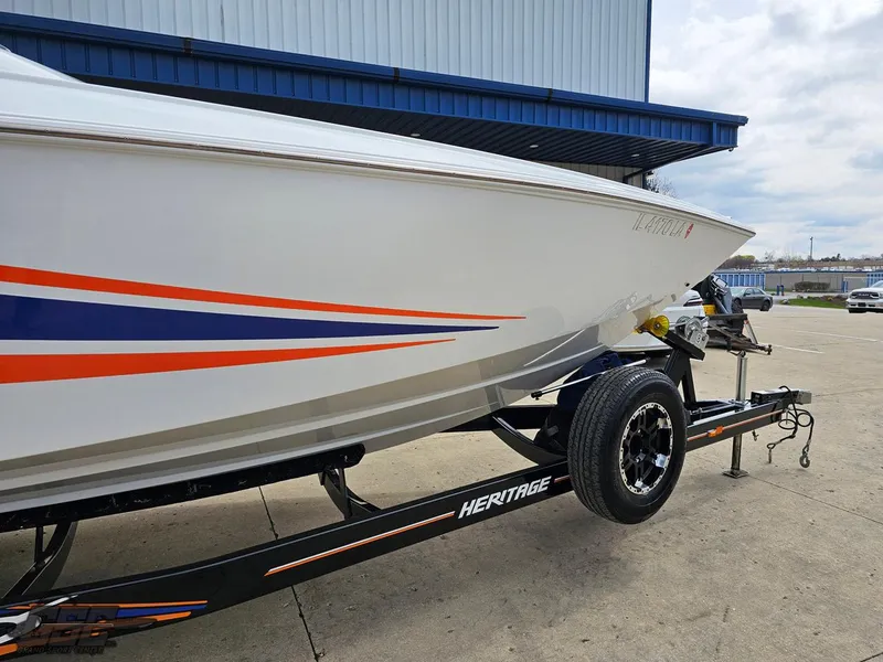 Slide: The Image of 2005 Baja 25 Outlaw boat on trailer with blue and orange stripes. - 7