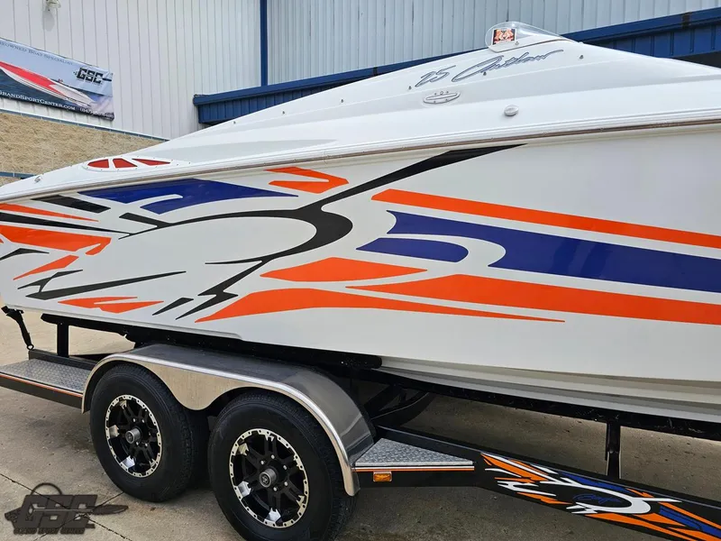 Slide: The Image of 2005 Baja 25 Outlaw boat with vibrant orange and blue graphics on a trailer. - 8