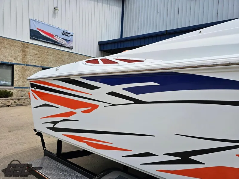 Slide: The Image of 2005 Baja 25 Outlaw boat with vibrant orange and black graphics on trailer. - 9
