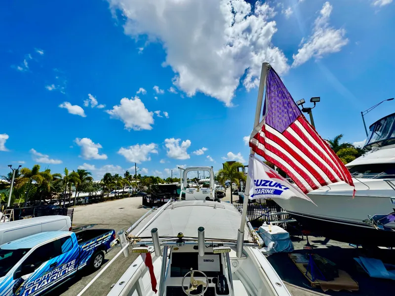 Slide: The Image of 1963 Bertram 25 Mark II sport cruiser with American flag, parked under a bright blue sky. - 2