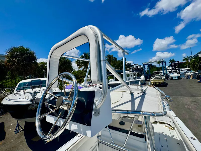 Slide: The Image of 1963 Bertram 25 Mark II convertible sport cruiser with steering wheel, docked under blue sky. - 3