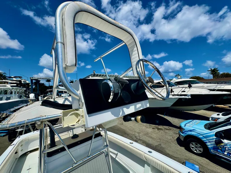 Slide: The Image of 1963 Bertram 25 Mark II convertible sport cruiser helm with steering wheel, docked under blue sky. - 45