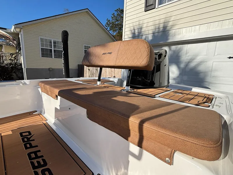 Slide: The Image of 2023 Sea Pro 172 Bay boat interior with tan seating and deck, parked near a house. - 16