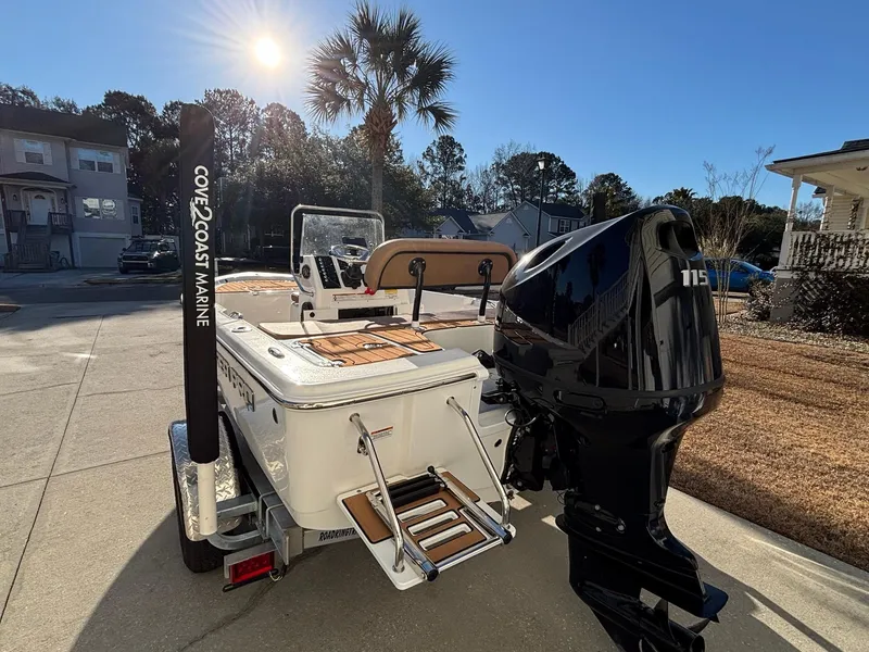 Slide: The Image of 2023 Sea Pro 172 Bay boat with powerful outboard motor, parked in sunny residential area. - 8