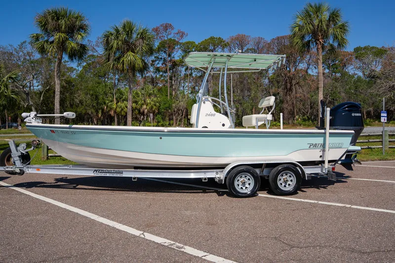 Slide: The Image of 2018 Pathfinder 2400 TRS boat on trailer, parked in sunny outdoor setting with palm trees. - 15