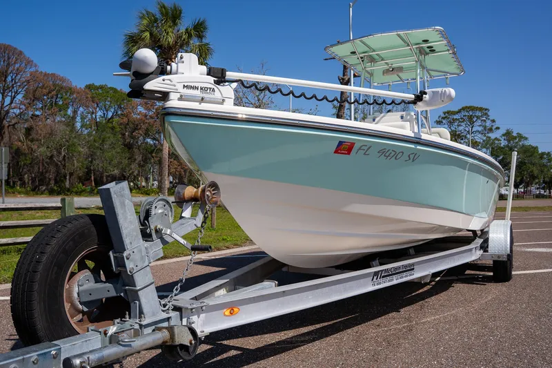 Slide: The Image of 2018 Pathfinder 2400 TRS boat on trailer, parked outdoors with trees in the background. - 19