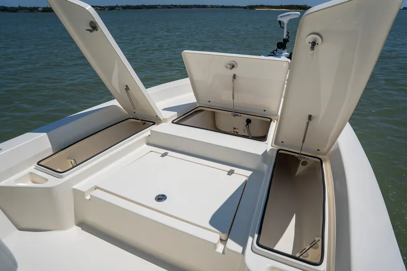 Slide: The Image of 2018 Pathfinder 2400 TRS boat with open storage compartments on calm water. - 30