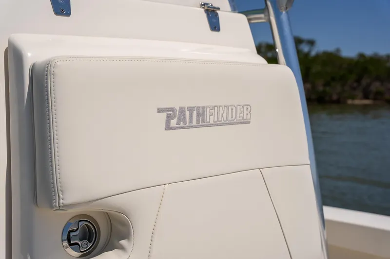 Slide: The Image of 2018 Pathfinder 2400 TRS boat seat with logo, near water. - 38