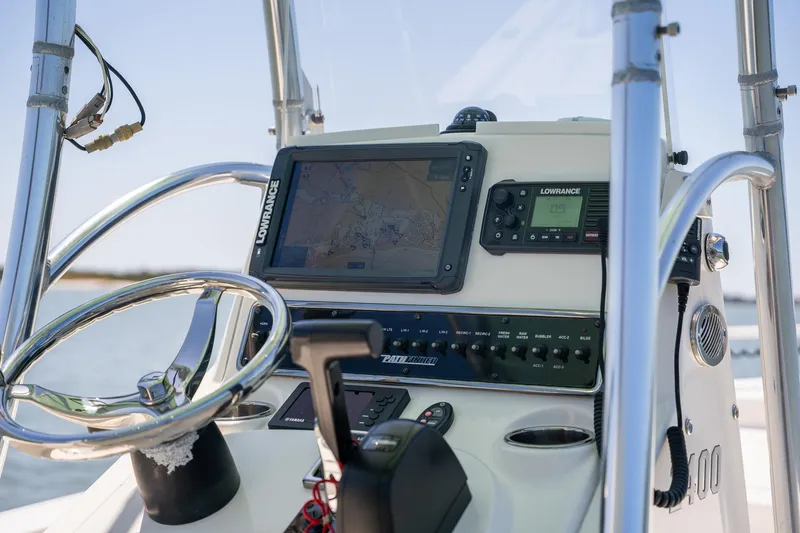 Slide: The Image of 2018 Pathfinder 2400 TRS boat dashboard with navigation equipment and steering wheel. - 46