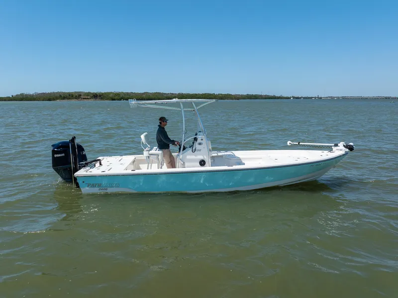 Slide: The Image of 2018 Pathfinder 2400 TRS boat on water, person steering, clear sky background. - 6