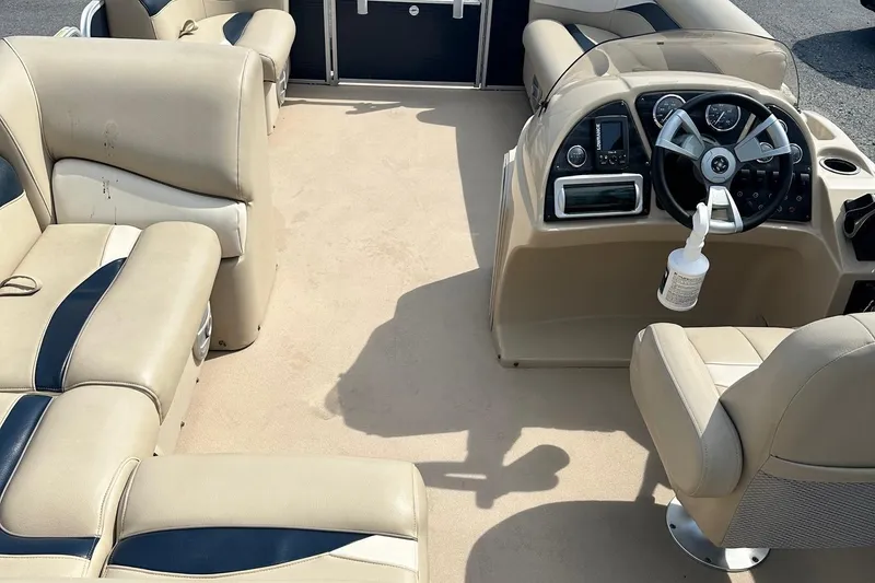 Slide: The Image of Interior of a 2015 Godfrey Sweetwater 2086FCS boat with beige seating and steering console. - 3