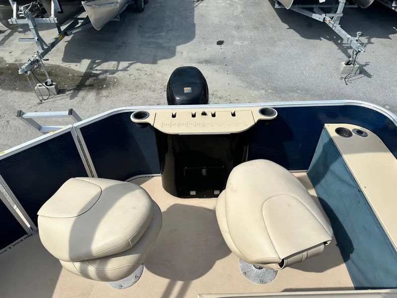 Slide: The Image of 2015 Godfrey Sweetwater 2086FCS boat interior with beige seats and control panel. - 9