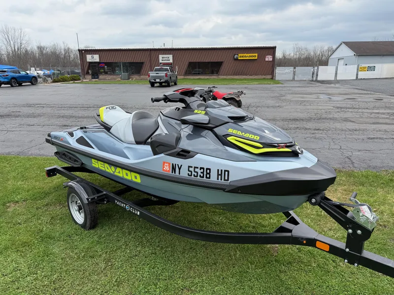 Slide: The Image of 2024 Sea-Doo RXT-X 325 in Ice Metal/Manta Green on trailer, parked outdoors. - 5