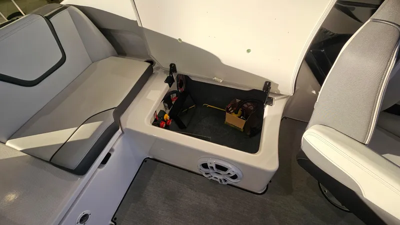 Slide: The Image of 2023 Yamaha Boats AR250 interior storage compartment with seating and speaker. - 23